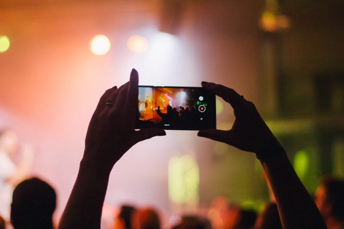 a single phone recording a live music gig in a crowd